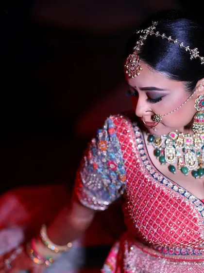 A side profile of the bride, showcasing the detailed embroidery on her blouse and her elegant bridal jewelry.