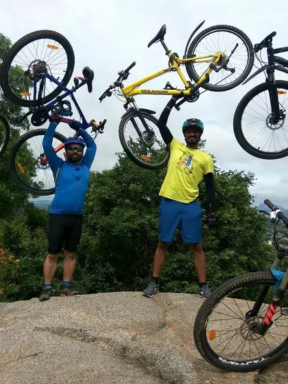 More riders joining in the "bikes up" celebration on top of a hill.