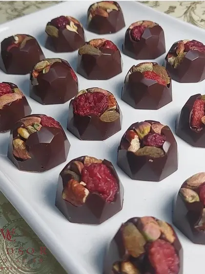 A closer look at the craft. These are my dark chocolate bonbons filled with a mix of toasted pistachios, almonds, and dried raspberries. I use only premium couverture chocolate and natural ingredients, ensuring every bite is a perfect balance of flavor and texture.