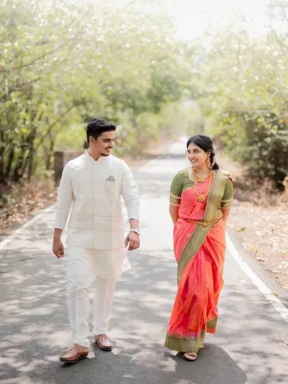 A happy, candid moment of the couple walking and talking together on a quiet road, showcasing their natural chemistry.