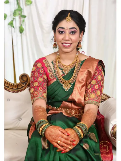 A picture perfect moment from an engagement. The rich green silk saree is draped to showcase the intricate blouse work, and the pleats are set to create a graceful fall as she sits.