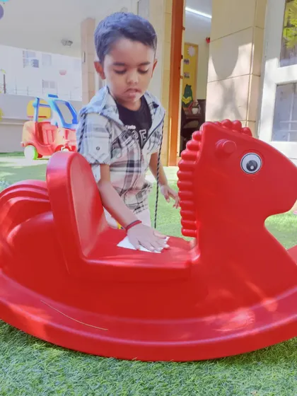 We teach our children to take care of their belongings and their environment. Here, a little Aster is carefully cleaning one of the rocking horses.