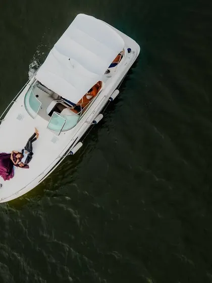 An aerial drone shot of a couple relaxing on a luxury yacht in Goa. This perspective offers a unique view of their exclusive experience, combining romance with a touch of opulence.
