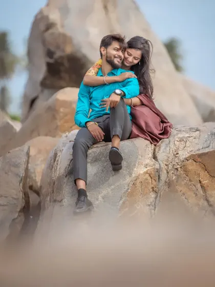 A sweet and natural moment during a pre-wedding shoot in Hampi. The couple's genuine smiles and the rugged, rocky landscape create a beautiful contrast.