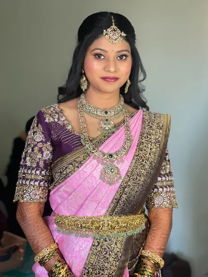 Pavitra looking stunning for her reception. Her makeup is a perfect balance of modern glam and elegance, paired with a beautiful pink and purple silk saree.