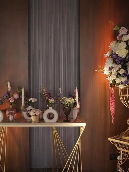A console table decorated with an array of flowers in modern vases, showing a blend of contemporary style with a romantic floral palette.