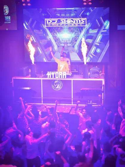 I don't just play the vibe, I am the vibe. Standing at the helm at Hydra with fire effects blazing, this image captures the intensity and control I bring to the console.