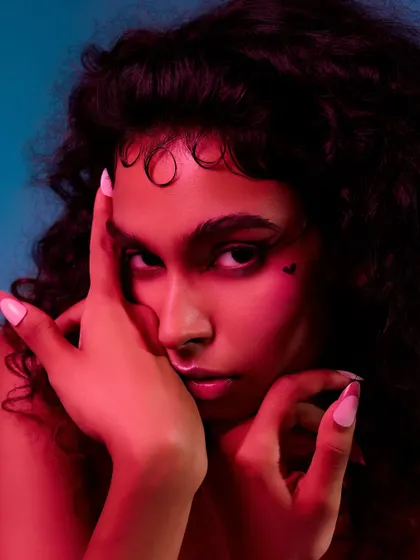 This close-up uses colored gels to create a vibrant, high-fashion mood. The red light adds warmth and intensity, focusing the viewer's attention on the model's expression and the heart-shaped makeup detail.