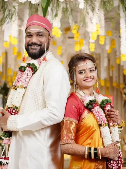 A classic back-to-back pose, with the couple looking happy and radiant in their wedding attire.