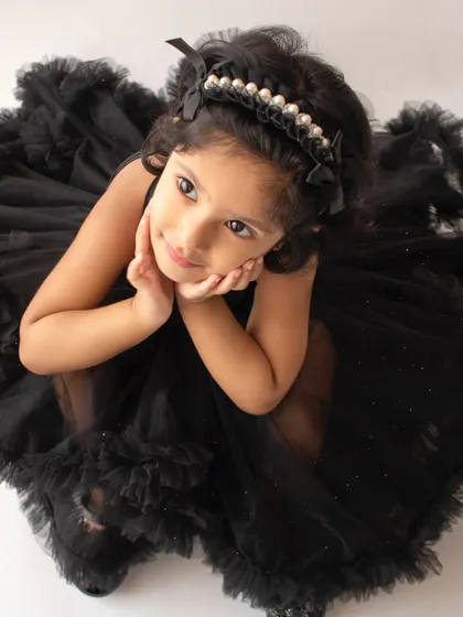 An overhead shot that highlights her thoughtful expression and the beautiful details of her pearl headband and dress.