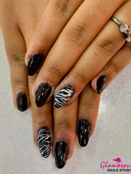 Take a walk on the wild side with this classic black manicure, featuring bold, hand-painted zebra print on the accent nails for a fierce touch.