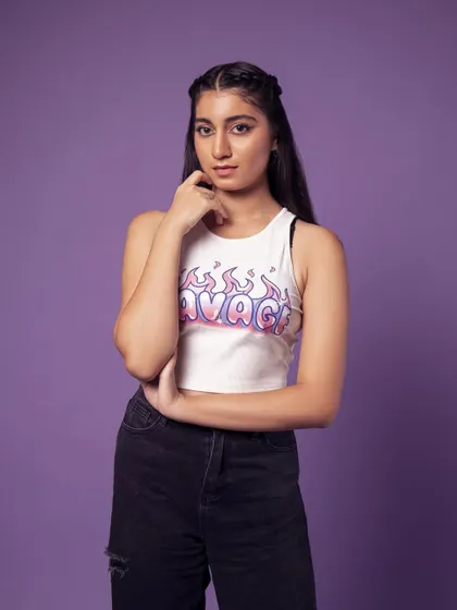 A three-quarter shot showing the full top and jeans. The pose is casual and confident.