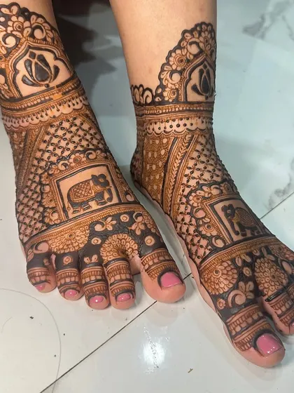 This design combines floral patterns with a central elephant motif, creating a balanced and beautiful look for the bride's feet.