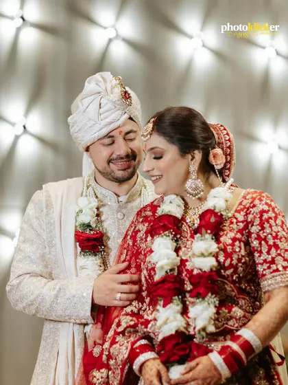 A candid, happy moment between the bride and groom right after their Jaimala ceremony, their smiles reflecting the joy of being newly married.