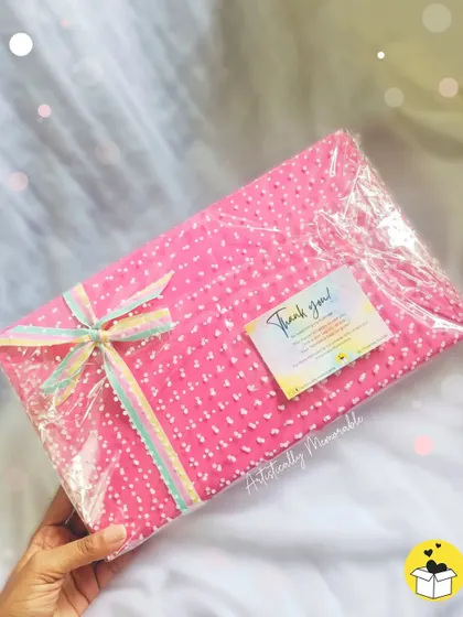 A hand-held view of the wrapped pink stationery hamper, complete with a "Thank you" card.