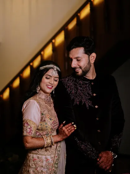 A sweet, candid moment of the couple on a staircase during their Sangeet or reception.