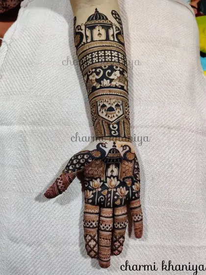 A full arm design packed with traditional elements. This mehendi features peacocks, lotuses, elephants, and palace architecture, creating a story on the arm.