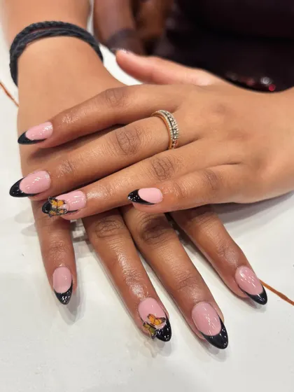 A modern take on the French manicure. We created a sharp black tip and added a beautiful, hand-painted monarch butterfly accent nail for a touch of nature-inspired elegance.