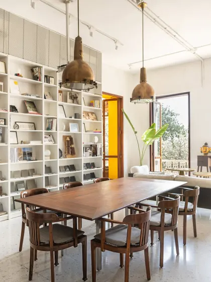 The main collaborative table in our studio, surrounded by bookshelves and bathed in sunlight. This space is the heart of our office, where we come together to develop ideas, review projects, and share knowledge.