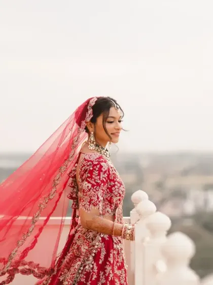 The bride's red veil flows in the wind as she stands on the palace balcony overlooking the city. This shot is both powerful and poetic, capturing a moment of quiet reflection.