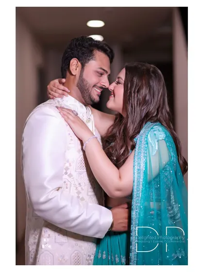 A candid photo of the couple sharing a happy, close moment, their smiles showing the genuine connection between them.