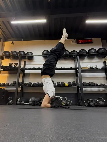 Headstand at Fitness First between the dumbbell racks after a class.