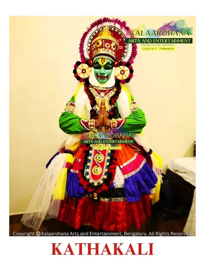 A full view of a Kathakali artist in traditional attire. Every detail, from the vibrant green 'Pacha' makeup signifying a heroic character to the elaborate costume, is meticulously prepared to preserve the authenticity of this classical dance-drama from Kerala.