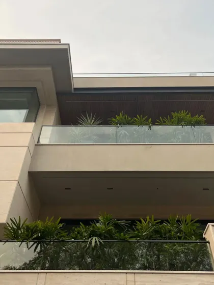 The deep overhangs and glass railings of the balconies create layered dimensions. We integrated planters along the balcony edges to bring greenery to every level of the home.