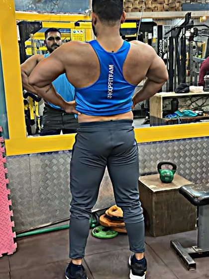 A lat spread pose, which emphasizes the width of the back. Exercises like wide-grip pull-ups and lat pulldowns are key for developing this V-taper.