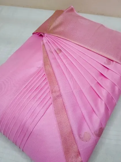 A soft pink saree with delicate motifs. The pleats are done to create a graceful and elegant drape, perfect for any occasion.