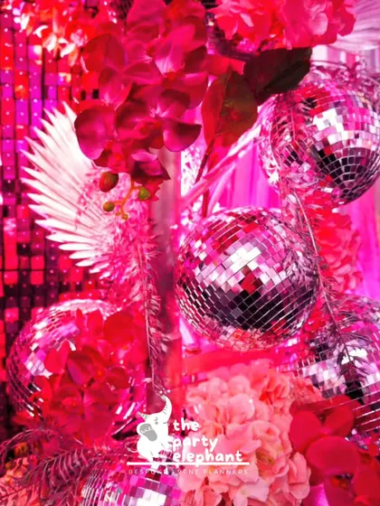 This detail shot shows how I combine different textures for a rich look, mixing shiny disco balls with soft red orchids and dried palm leaves for a unique floral arrangement.