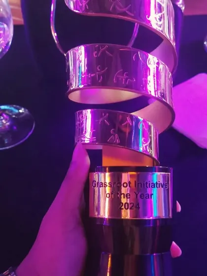 A close-up of the 'Grassroot Initiative of the Year 2024' trophy. This award recognizes the incredible impact of using sport as a tool for social change in often overlooked communities.