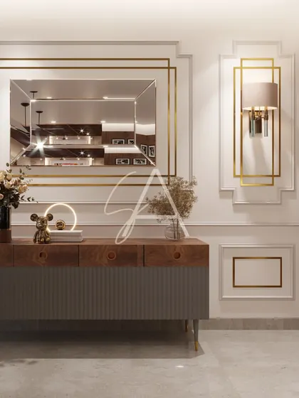 This console area demonstrates my love for refined details. The wall molding with gold accents, the elegant mirror, and the modern sideboard come together to create a look of sophisticated, contemporary glamour.