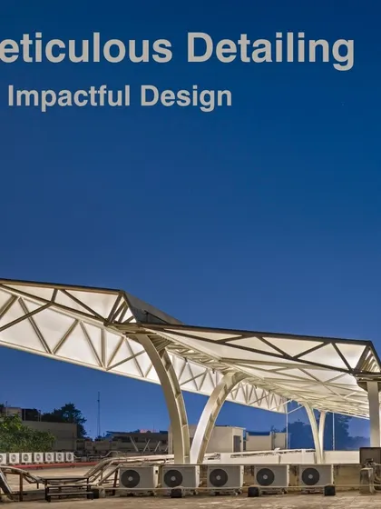 The tensile structure at dusk, with integrated lighting illuminating the canopy. This detail ensures the central assembly area is versatile for evening activities and events.