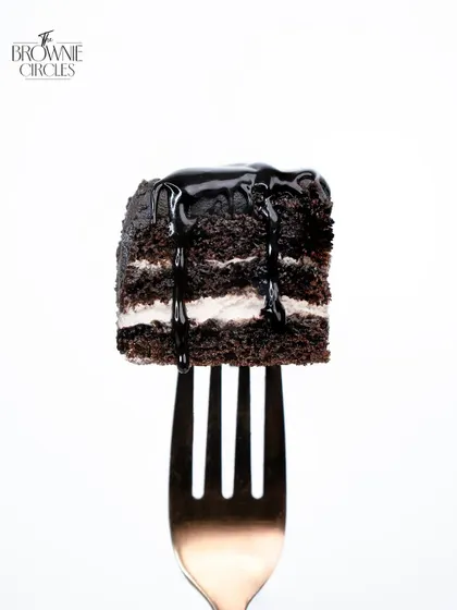 A perfect forkful of our layered chocolate cake, showcasing its moist texture and rich ganache. A true slice of love.