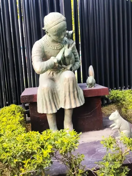 This sculpture captures a tender moment of a girl with a rabbit and squirrels. It's a perfect example of our garden art that adds a story to the landscape.