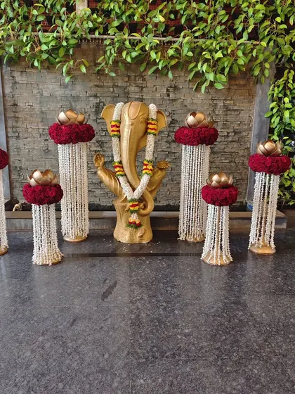 An elegant and spiritual welcome setup centered around a golden Ganesha idol. We flanked the deity with pillars of jasmine garlands and red rose arrangements, blending traditional reverence with beautiful event decor.