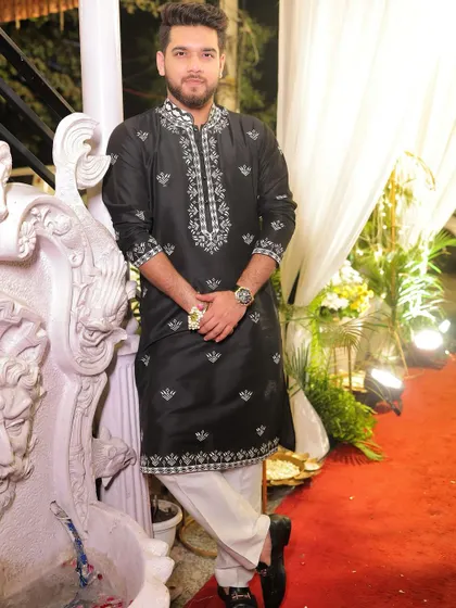 A full-length view of the black and white embroidered kurta, paired with white trousers. This is a timeless ethnic look, perfect for making a sophisticated impression at any event.