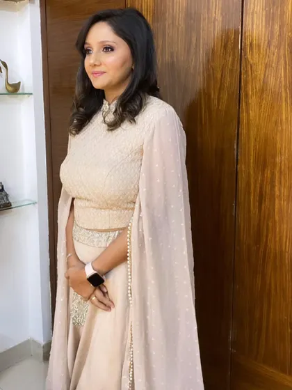 The full look, featuring an elegant beige outfit with cape sleeves. The makeup is polished and sophisticated, tying the whole ensemble together beautifully.