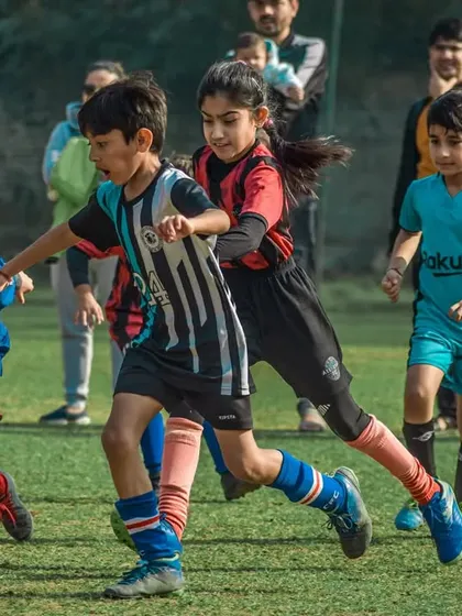 A mix of boys and girls competing for the ball, showing the inclusive spirit of the Pride Cup finals.