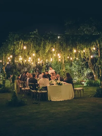 A wider view of the intimate outdoor dinner, showing guests enjoying the magical ambiance.