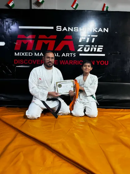 This young student has earned his orange belt. Our structured belt system provides clear goals for our students to strive for.