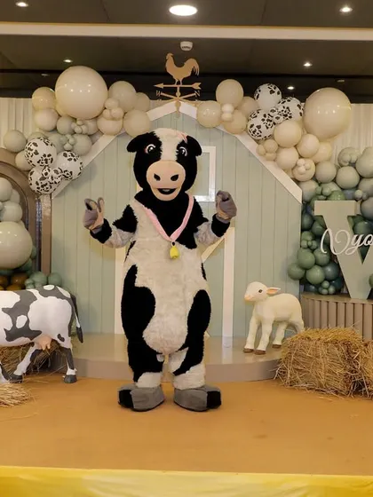 A cow mascot entertains the guests, bringing the farm theme to life and creating a fun photo opportunity.