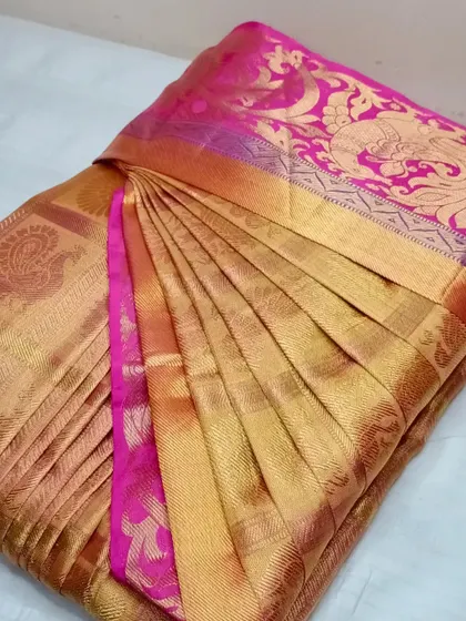The combination of gold and pink in this silk saree makes it ideal for festive events. I ensure the pleats are perfectly aligned to show off the rich border and fabric.