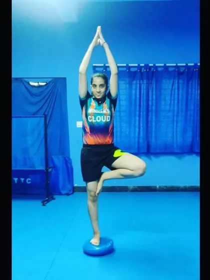 One of our players in the tree pose (Vrikshasana) during a yoga session, showcasing the focus and balance we cultivate in our athletes.