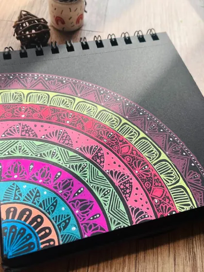 A close-up view of the detailed patterns within the rainbow semi-circle mandala.