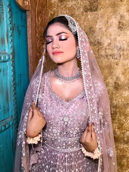 A serene, eyes-closed shot showing the soft, shimmery eye makeup.