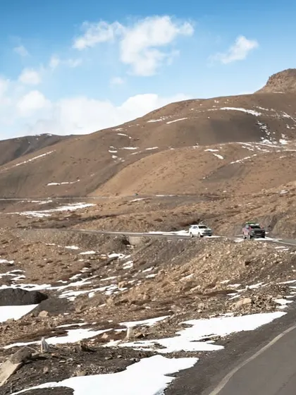 A series of images showing a convoy of 4x4 SUVs navigating the winding, mountainous roads of Spiti. These shots highlight the challenging yet rewarding nature of the expedition.