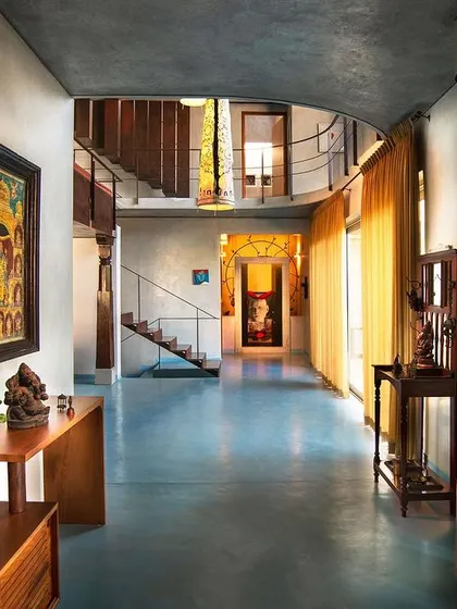 An entryway that immediately establishes a connection to Indian heritage. We incorporated a traditional carved wooden pillar and antique furniture pieces against a modern, minimalist backdrop of cool blue flooring and white walls, blending old and new.