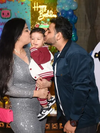 A heartwarming moment as mom and dad give the birthday boy a kiss on each cheek.